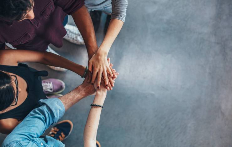 group of people putting their hands in