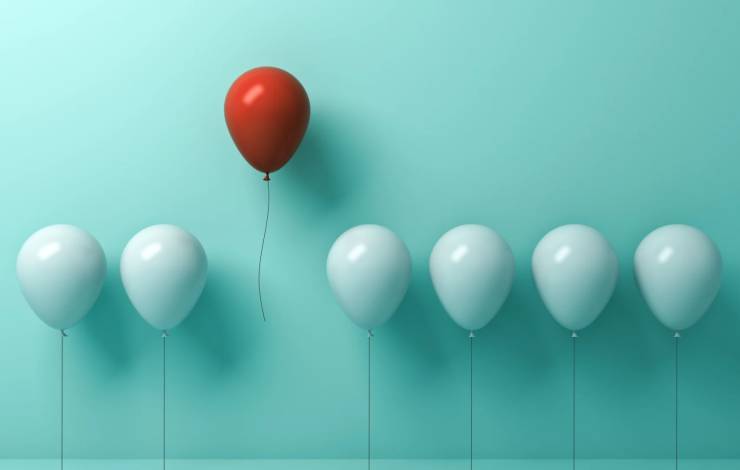 single red balloon standing out among white balloons