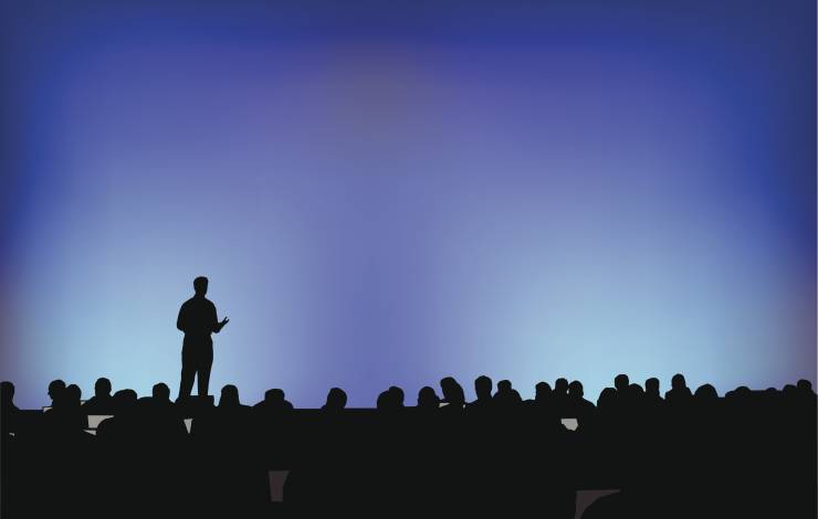 Person speaking in front of a crowd at a conference