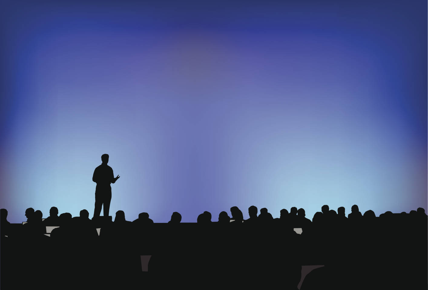 Person speaking in front of a crowd at a conference