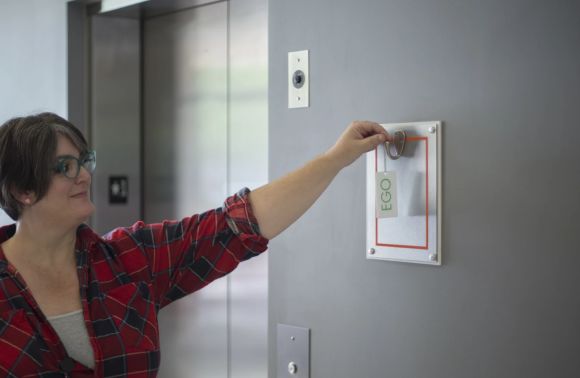 person hanging a tag at the door that represents their ego