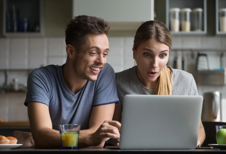 Happy couple in front of laptop